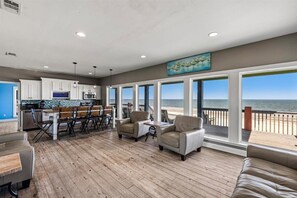 A spacious deck with a view of the ocean, a kitchen area, and seating arrangements. - Beachfront 5BR | Gulf Views + Game Room with Pool Table (Port Bolivar)