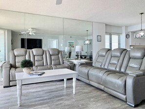 Ein Wohnzimmer mit Sofa, Couchtisch, Lampe und Fernseher.