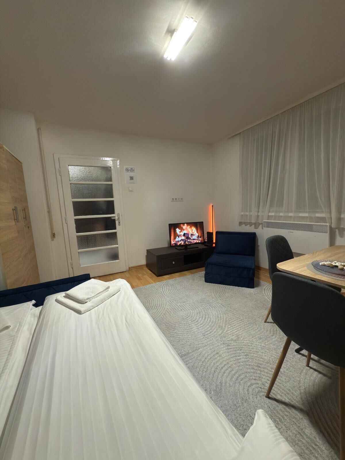 Una habitación de hotel con cama, televisión, escritorio y silla.
