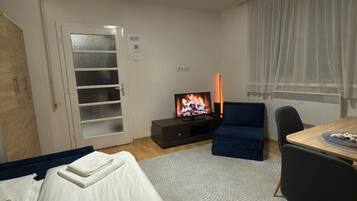 Ett hotellrum med en säng, en TV, ett skrivbord och en stol.