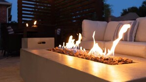 Un foyer agrémenté d’une pergola en bois et d’un canapé en arrière-plan.