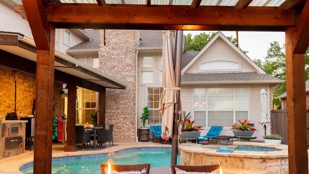 Un jardin avec une piscine, un espace salon extérieur et une pergola.
