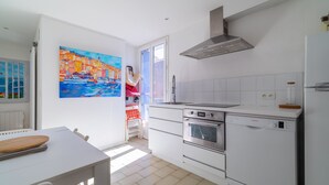 Una cocina moderna con gabinetes blancos, un lavavajillas Bosch, un horno y una campana extractora de acero inoxidable.