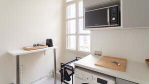 A compact kitchen with a microwave, a washing machine, and a drying rack. - Modjesko - Au coeur de Rennes (Rennes)