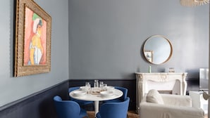 A dining area with a round table, blue chairs, and a white sofa. - Modjesko - Au coeur de Rennes (Rennes)