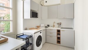 A compact kitchen with a washing machine, microwave, and a sink. - Modjesko - Au coeur de Rennes (Rennes)