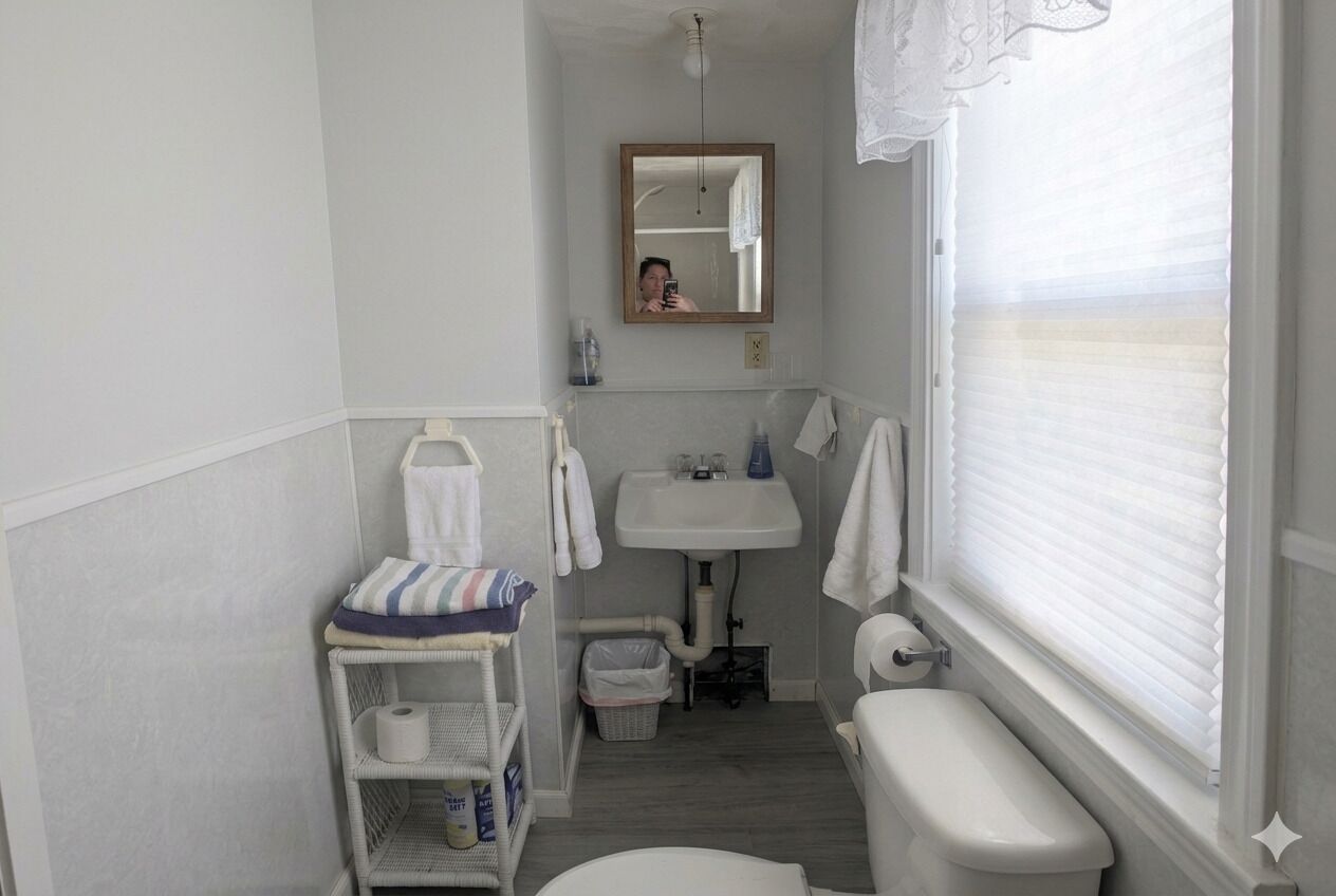 Une petite salle de bain comprenant des toilettes, un lavabo et un miroir.