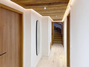 A hallway with wooden flooring, white walls, and a wooden ceiling. - 300m from ski slopes, balcony, fireplace or stove, parking, ski locker, 143m², La Rosière (Montvalezan)