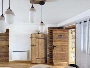 A room with a wooden wardrobe, a white air conditioning unit, and a wooden door with a sign. - 300m from ski slopes, terrace, parking, ski locker, 162m², La Rosière (Montvalezan)