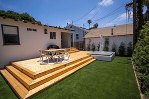 A backyard with a wooden deck, a dining table with chairs, and a hot tub. - BRAND NEW - Single-Family Solana Beach House, Steps from the Beach. (Solana Beach)