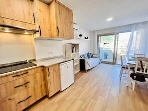 Eine moderne Küche mit Holzausstattung, einem eingebauten Geschirrspüler und einem Essbereich mit Tisch und Stühlen.