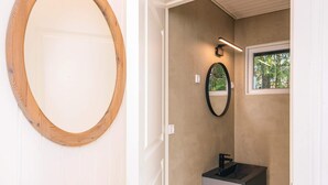 A bathroom with a wooden-framed mirror, a black sink, and a small window with a view of greenery. - 4 Star Holiday Home in Ansager (Ansager)