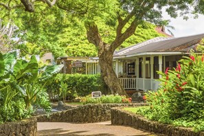 A garden area with a stone pathway, a registration sign, and a building with a porch. - Kiahuna 216 At Koloa Kai Ocean View  PBAC Access (Koloa)