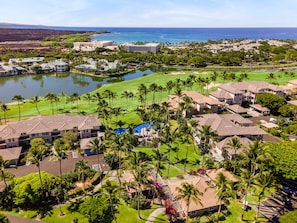 Ein Resort mit mehreren Gebäuden, einem Golfplatz und einem Gewässer.