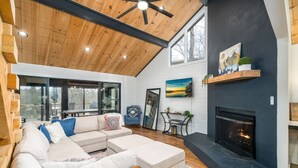 Een moderne woonkamer met een modulaire bank, een open haard en een groot raam.