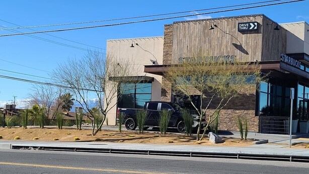 A Starbucks store with a drive-thru, a black SUV parked in front, and a clear sky. - Cozy Cove #6 (Apple Valley)