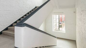 A staircase in a room with white walls and a window.