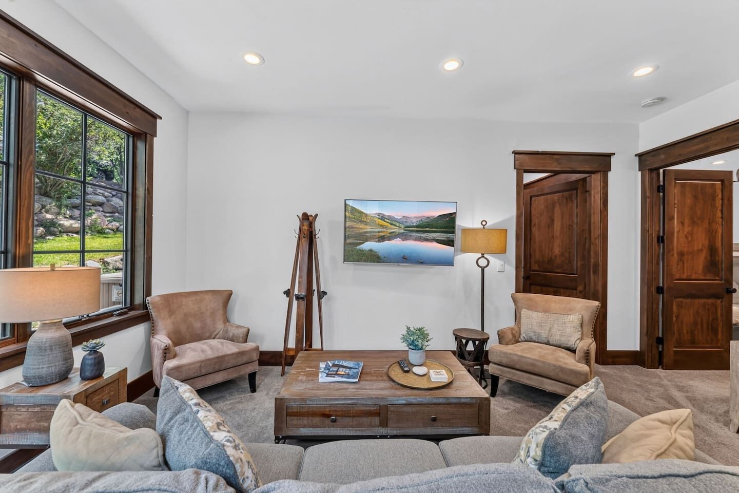 A living room with a sofa set, a coffee table, a painting, and a lamp.
