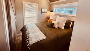 Une chambre à coucher avec un lit, une fenêtre et un plafond en bois.