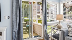 Une pièce dotée d’une porte-fenêtre coulissante, d’un canapé, d’une lampe et offrant une vue sur l’extérieur.