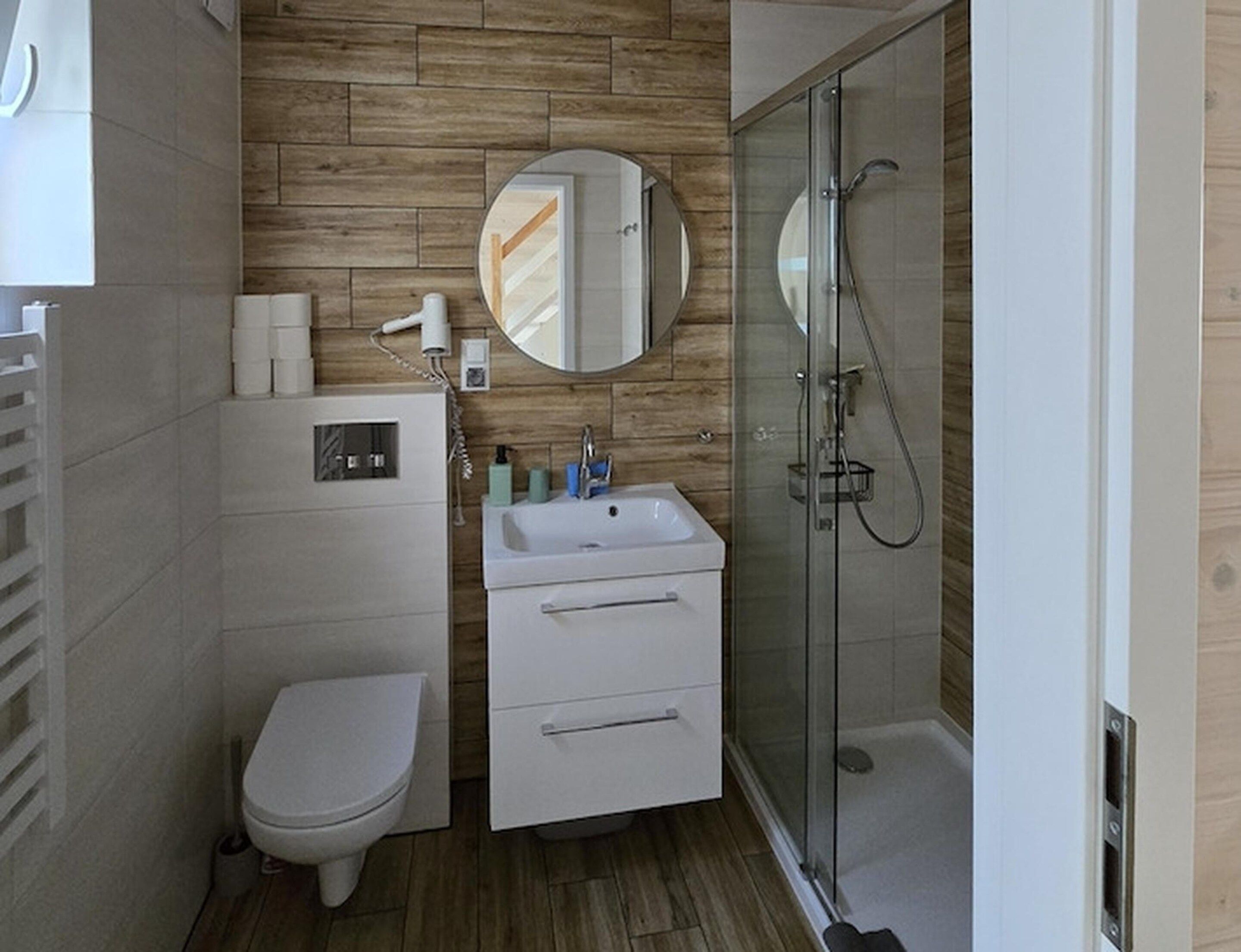 Un bagno moderno con toilette, lavandino e doccia.