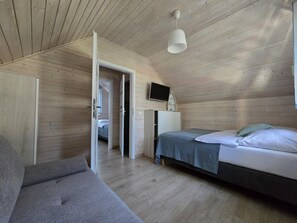 A bedroom with a bed, a sofa, a TV, and a wardrobe. - Large Holiday Homes With Beautiful Gardens (Rewal)