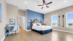 A bedroom with a bed, a desk, a chair, a ceiling fan, and windows. - Vista del Mar II - Coastal Calm PCB 301 (Panama City Beach)