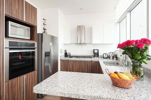 Eine moderne Küche mit eingebauten Geräten, einer Arbeitsplatte aus Granit und einer Blumenvase.