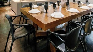 A modern dining area with a long wooden table set for six, surrounded by black chairs. - 6BR house in Amsterdam street | Parque México (Mexico City)