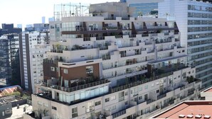 Un edificio de varios pisos con balcones, ventanas amplias y un diseño arquitectónico moderno.