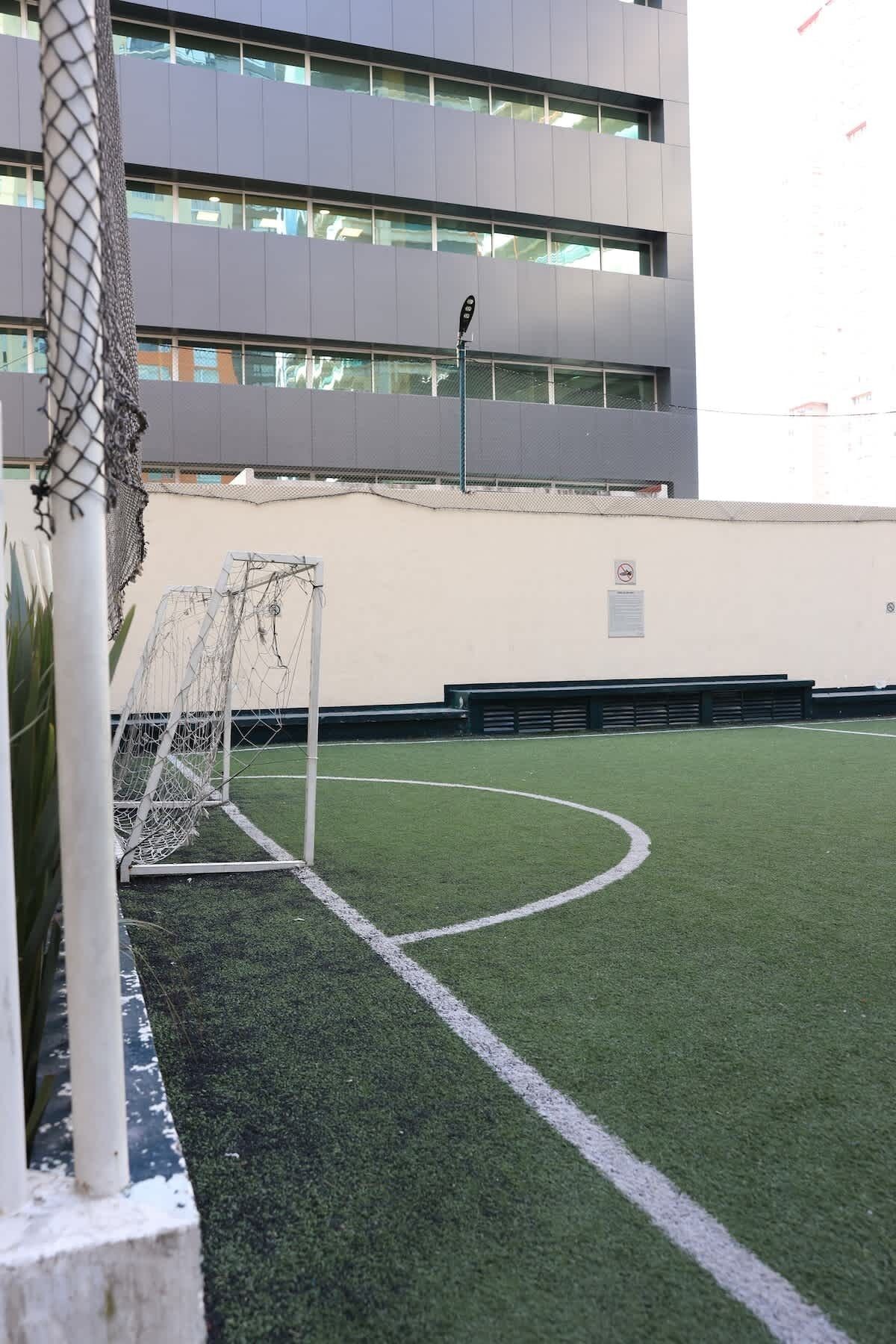 Ein Fußballfeld mit einem Tor und einem Gebäude im Hintergrund.