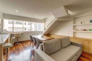 Ein modernes Interieur mit Essbereich, Sofa und Treppe.
