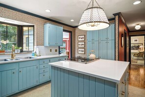 A kitchen with blue cabinets, a white island, and a hanging light fixture. - Cedar Hall - A Charming Vintage Estate (Lebanon)