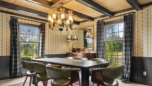 A dining room with a large table, six chairs, a chandelier, and large windows with curtains. - Cedar Hall - A Charming Vintage Estate (Lebanon)