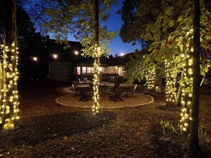 An outdoor seating area with string lights, a dining table, and chairs. - Cedar Hall - A Charming Vintage Estate (Lebanon)