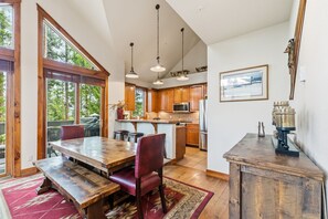 A spacious kitchen with wooden cabinets, a central island, and pendant lighting. - Breck Basecamp | Deck + Hot Tub + Walk Everywhere (Breckenridge)