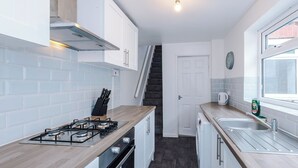 A compact kitchen with a gas stove, oven, and a small sink.