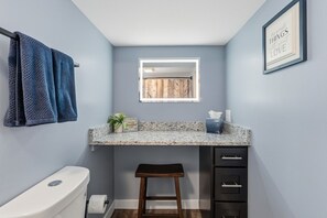 Ein Badezimmer mit Toilette, Waschbecken und einem gerahmten Zitat an der Wand.