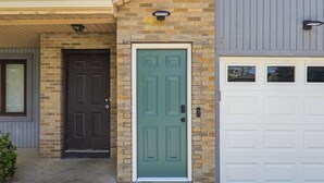 A house with a brown door, a green door, and a white garage door. - Modern Reynoldsburg Retreat Near Columbus (Reynoldsburg)