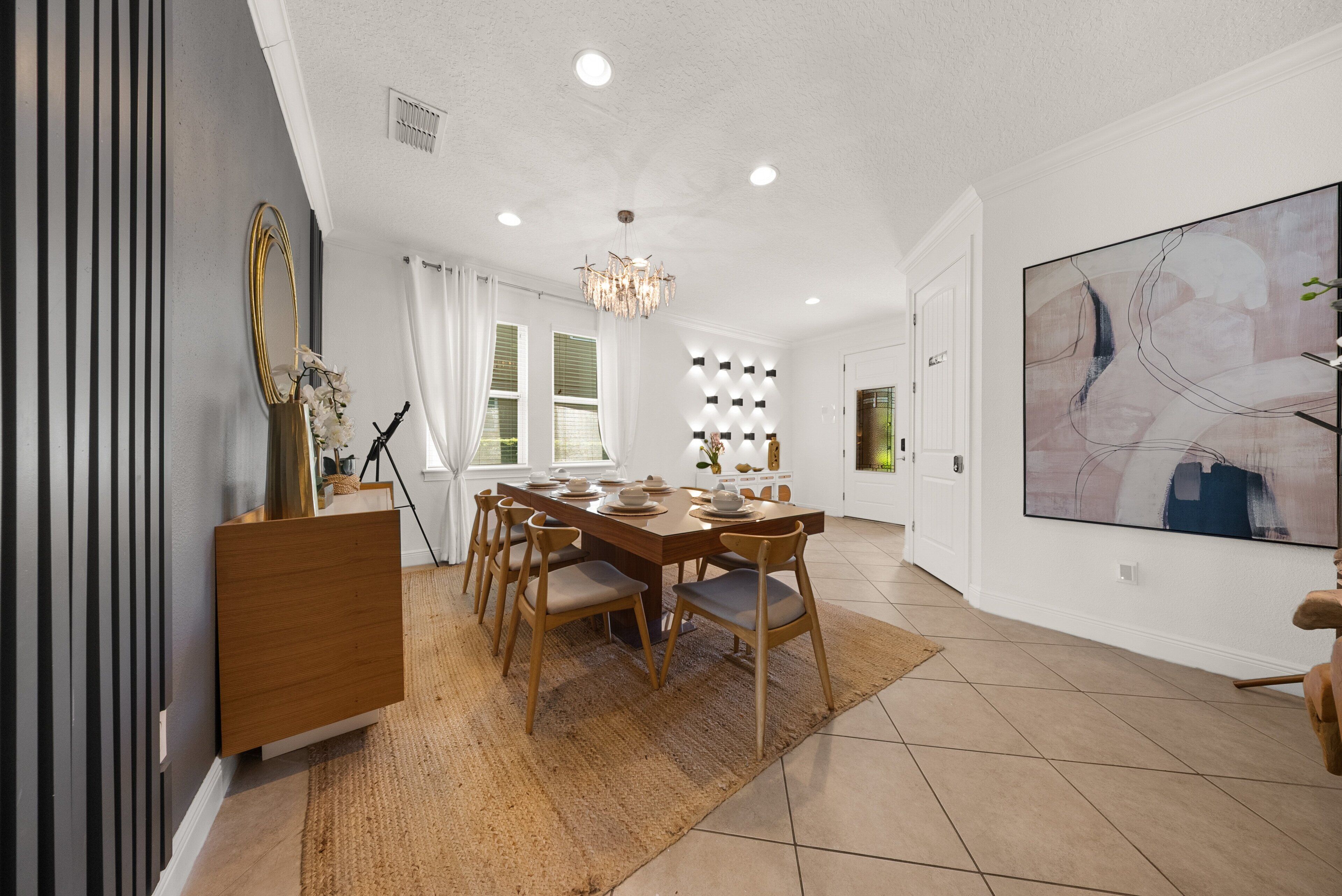 A dining area with a wooden table, chairs, and a chandelier.