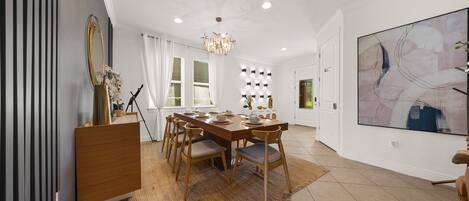 A dining area with a wooden table, chairs, and a chandelier.
