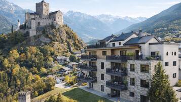 Un castillo en una colina con edificios modernos al frente.