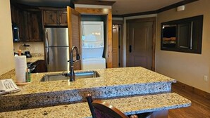 Una cocina con encimeras de granito, electrodomésticos de acero inoxidable y armarios de madera.