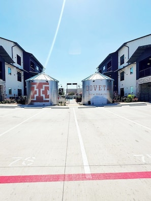Un parking avec deux grands silos cylindriques portant l’inscription « DOVETTA NEW BRUNFELD ».