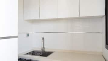 Frigorífico pequeño, horno, placa de cocina y utensilios de cocina