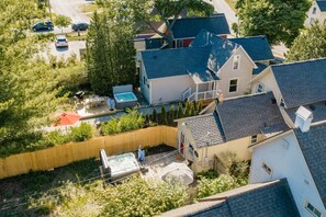 Een woonwijk met een huis, uitgerust met een ruim terras, een hottub en een zwembad.