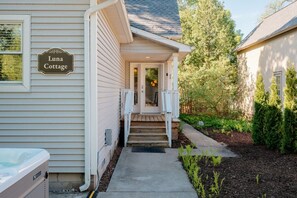 Et hus kaldet Luna Cottage med en veranda, trin op til indgangen og et lille haveområde.