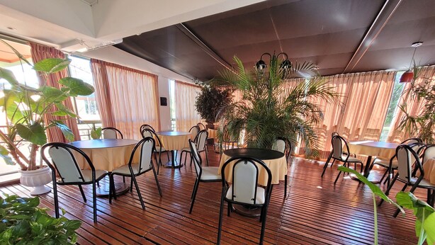 A restaurant with wooden flooring, round tables, and chairs. - El Mirador (Villa Carlos Paz)