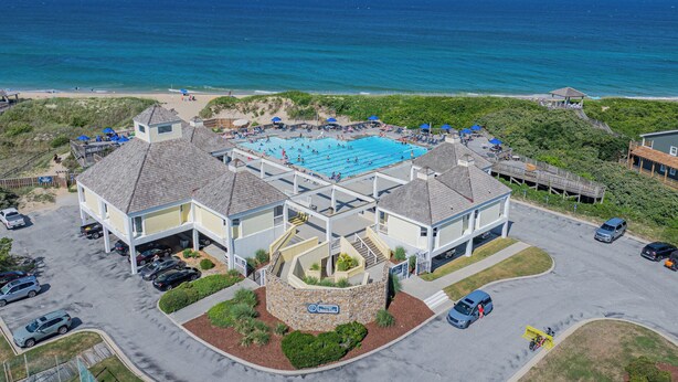 Ein Hotel an der Küste mit Pool, Parkplatz und Meerblick.