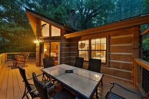 A log cabin with a deck, a dining table, and chairs. - Cedar Ridge Haven | Hot Tub, Fireplace & More! (Gatlinburg)